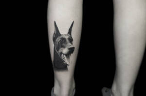 Tattoo Anansi Studio München Nastja black and white dog portrait leg doberman