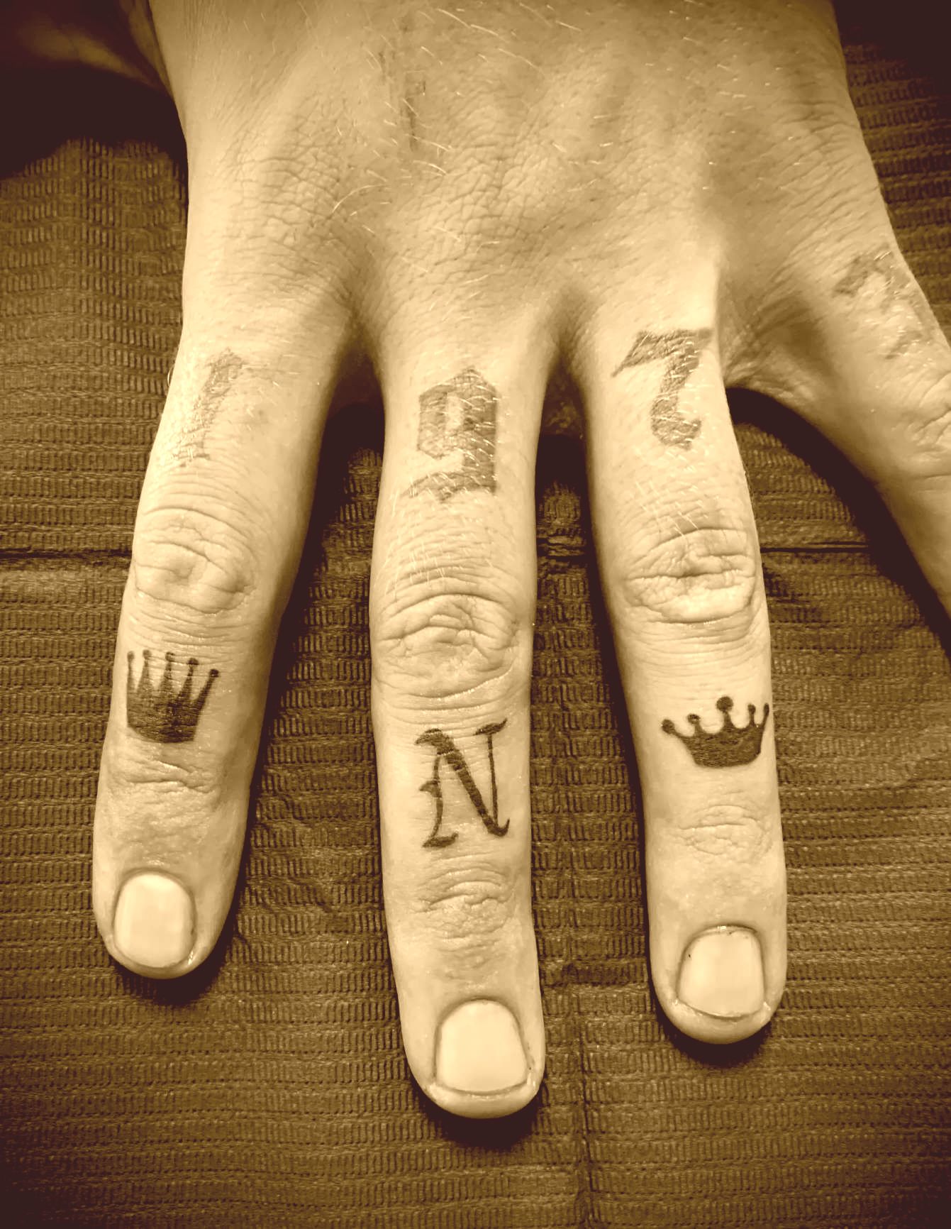 Tattoo Studio Anansi München Munich Vedran symbols small tattoos finger king crown black letter