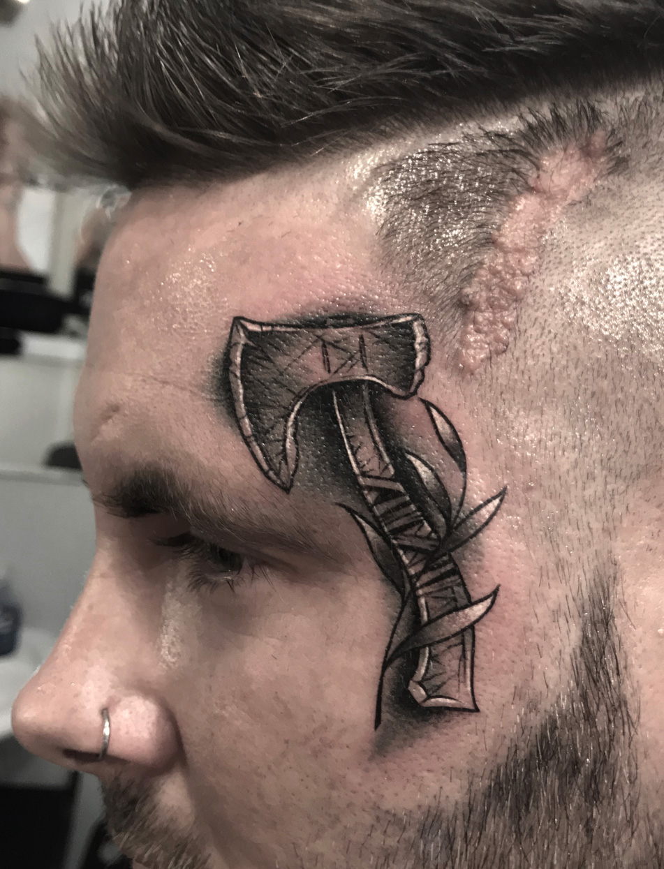 Tattoo-Anansi-Studio-Munchen-Munich-Haidhausen-Alex-facetattoo-face-axe-leaves-branches-native-weapon-best-black-and-grey.jpg