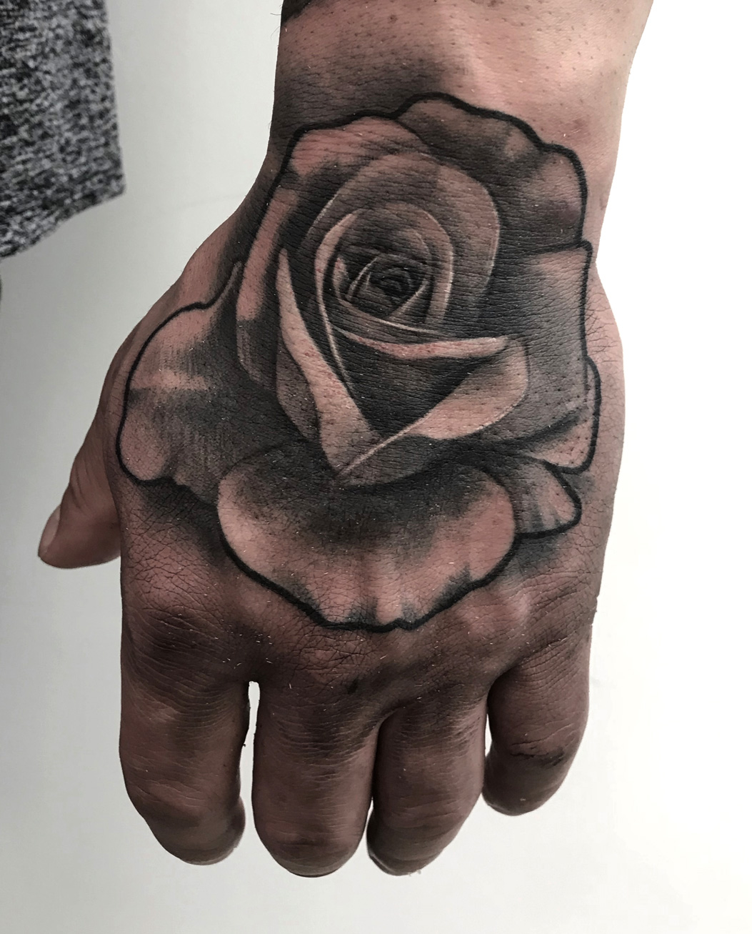 Tattoo-Anansi-Studio-Munchen-Munich-Haidhausen-Alex-hand-rose-classic-timeless-design-flower-best-black-and-grey-realism.jpg