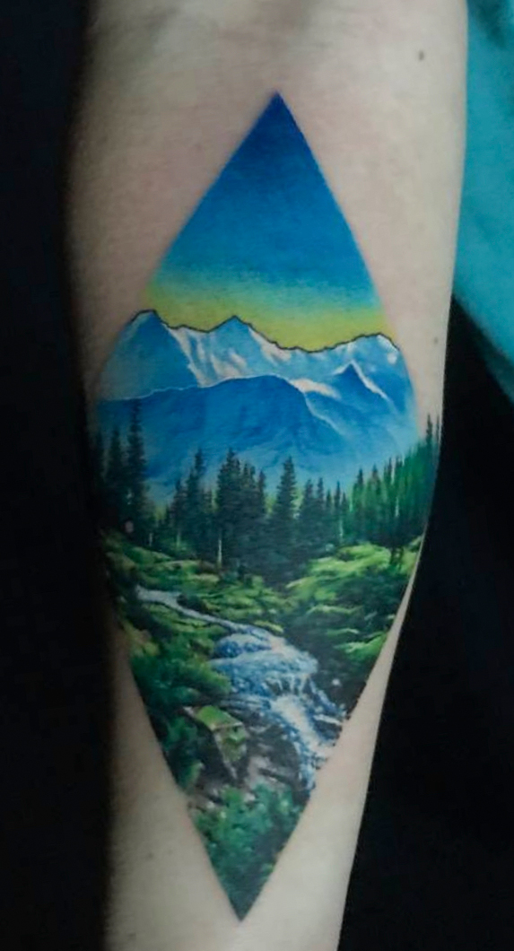 Tattoo-Anansi-Studio-Munchen-Munich-Haidhausen-Alex-forearm-mountains-wild-landscape-riverrun-forest-trees-idyll-calm-place-nature-best-colour-realism.jpg